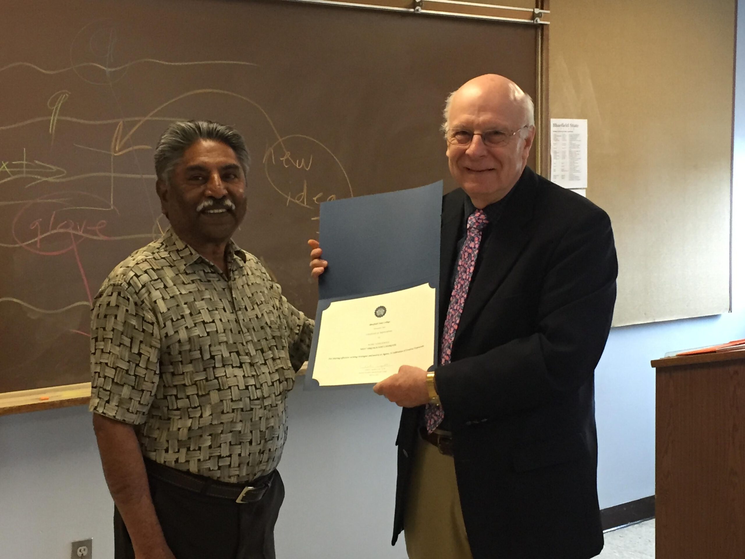 (photo cutline)--West Virginia Poet Laureate (2012) Mark Harshman (right) receives a certificate of appreciation from Dr. Sudhakar Jamkhandi (Coordinator of International Initiatives @ Bluefield State College) during his visit to BSC. Harshman delivered a writers workshop at the College, then took part in the sixth annual "Agora, A Celebration of Creative Expression," at the College.