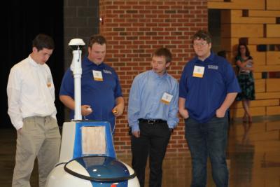 Pictured are BSC robotics team student members (dark blue shirts) are detailing the capabilities of their intelligent ground vehicle to members of the Ridgeview High School robotics team.