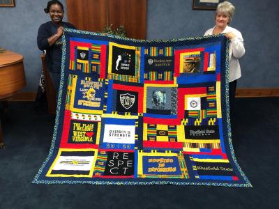 BSC Counselor Tamara Hill (left) and Dr. Sarita Rhonemus, Director/Multi-Locations and RBA Program, are pictured as they display the quilt.