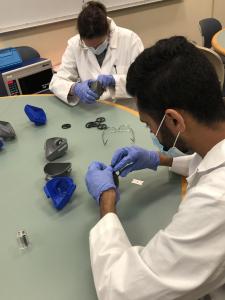 Bluefield State College student Syed Monis Ali (foreground) and Elizabeth Walters, BSC Academic Laboratory Instructional Assistant, are pictured as they install filters into N95 replica respirator masks.  The masks were produced by BSC through a collaboration involving BSC Academic Schools and Bluefield Regional Medical Center.  The masks were presented to BRMC Emergency Management Director Richard Cox on April 23. 
