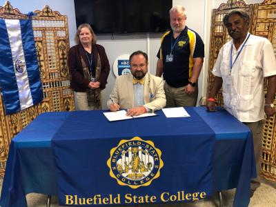 Bluefield State College has entered into a formal Memorandum of Understanding (MOU) with the ESCUELA ESPECIALIZADA EN INGENIERIA ITCA FEPADE in El Salvador.  Dr. Ted Lewis (seated), Bluefield State College Provost, is pictured with Interim Dean of the BSC School of STEM Dr. Jan Czarnecki (standing/left),Bluefield State Computer Science Chairman Dr. Bill Bennett (standing, right) and Dr. Sudhakar R. Jamkhandi (standing, far right), Director/International Initiatives at BSC, during the signing ceremony at the