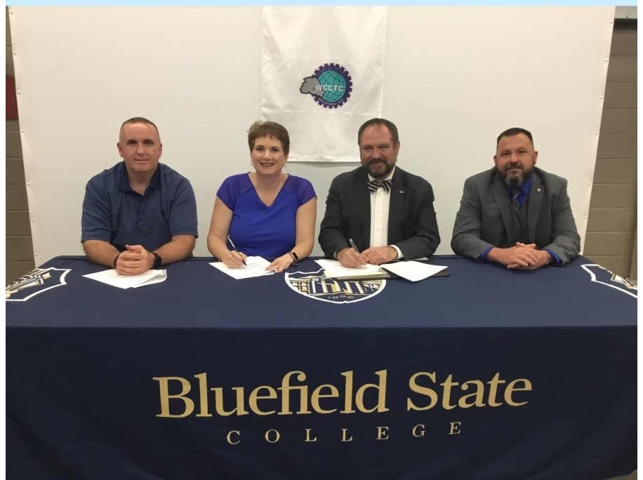 A new Articulation Agreement involving Bluefield State College, the Wyoming County Board of Education, and the Wyoming County Career and Technical Center, permits qualifying students to earn 14 hours of college credit while completing the Center’s Law Enforcement, Corrections and Security Cluster.  Pictured at the agreement's signing ceremony are (left-to-right) Mike Johnson (Law and Public Safety Instructor/Wyoming County Career and Technical Center), Ms. Stacey Lusk (Principal/Wyoming County Career and Te